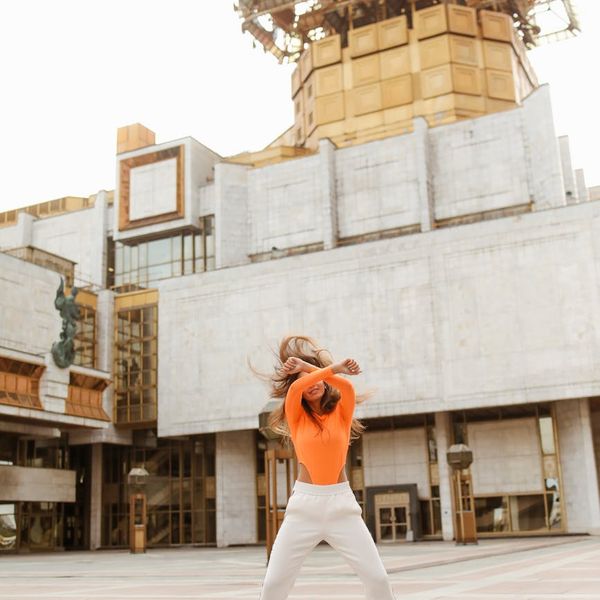 Person feeling energized and stretching in a bright, open space.